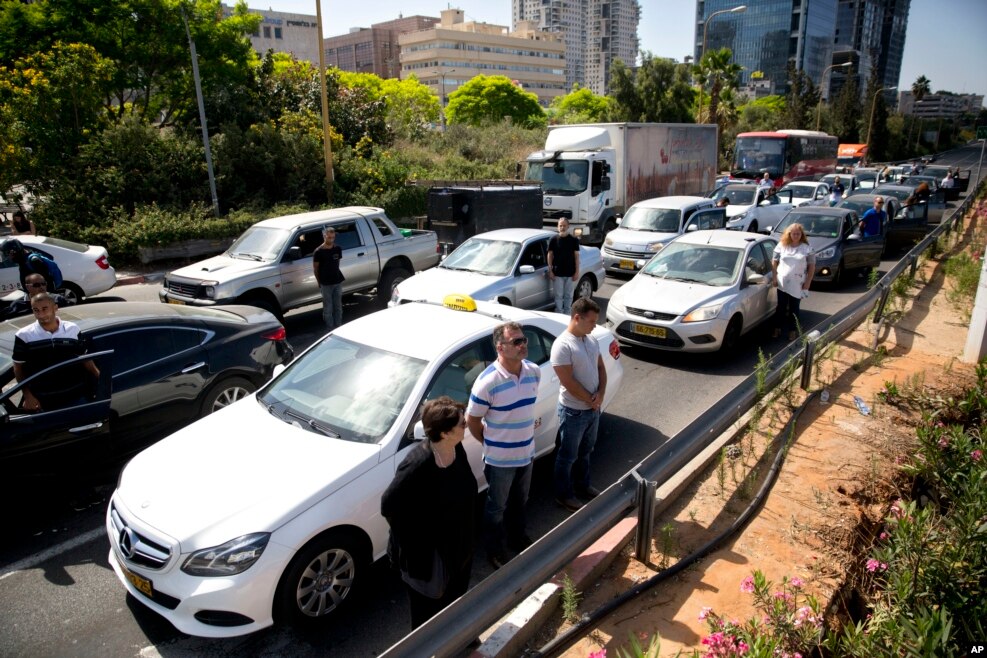 Israelis stand still next to their cars as a siren sounds in memory of victims of the Holocaust in Tel Aviv, Israel.