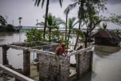 Villagers collect bricks from their house that was destroyed by natural disasters at Pratap Nagar in Satkhira, Bangladesh on Oct. 5, 2021. (AP Photo/Mahmud Hossain Opu)