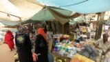 FILE- Women wait to buy things for Ramadan at a central food market in Khartoum, Sudan, July 18, 2012. Sudan's currency fell close to its historical low against the dollar as demand for imported food surged before the holy Muslim month of Ramadan, driving up pr