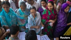 Voters get their names checked in a voter's lists at a polling station during the final phase of the general election in Varanasi in the northern Indian state of Uttar Pradesh, May 12, 2014. 