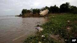 FILE - A Cambodian fisherman takes off his fishing net at Mekong river bank of Koh Norea village in Phnom Penh.