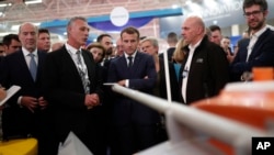 FILE - French President Emmanuel Macron, center, visits a stand at Euronaval, the world naval defense exhibition in Le Bourget near Paris, Oct. 23, 2018. France banned Israeli firms from participating in an upcoming military naval trade show to be held on Nov. 4 -7, 2024.