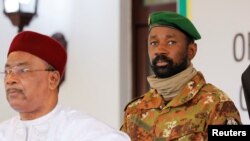 FILE—Colonel Assimi Goita, leader of Malian military junta, looks on while he stands behind Niger's President Mahamadou Issoufou during a photo opportunity after the Economic Community of West African States (ECOWAS) consultative meeting in Accra, Ghana September 15, 2020. 