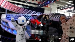 Sebuah robot menghibur pengunjung di sebuah stand produsen mobil China dalam ajang "China Auto 2018" di Beijing, China, 26 April 2018. (AP Photo/Ng Han Guan).