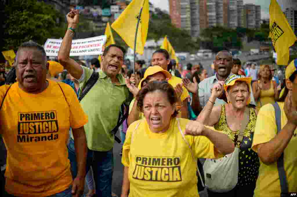 Venezuelan opposition activists march along a street of Caracas, March 31, 2017 chanting slogans against the government of President Nicolas Maduro. 