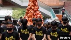 香港大学的学生在悼念六四死难者的“国殇之柱”前向死难者默哀。（2021年6月4日）