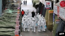 Yadda jami'an lafiya ke yin feshi a wata kasuwa a Korea ta Kudu domin dakile yaduwar cutar coronavirus da ta kama mutum sama da 500 a kasar
