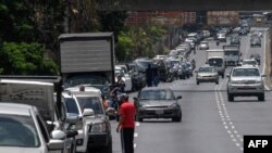 Conductores hacen cola para llenar los tanques de sus automóviles cerca de una estación de servicio, en Caracas, el 3 de junio de 2020, en medio de la pandemia del coronavirus.