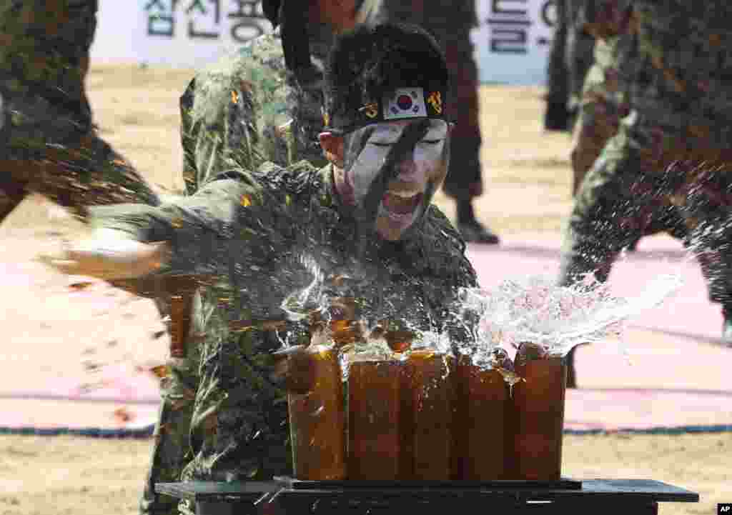 Seorang tentara dari pasukan khusus Angkatan Darat Korea Selatan menggunakan tangannya untuk memecahkan botol-botol bir sebagai bagian dari acara peringatan pertempuran Naktong Bulge di dekat jembatan kereta api Waegwan di Waegwan, Korea Selatan. 