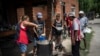 Voluntarios sirven almuerzos calientes en el comedor social "Regalo de Dios" en el barrio Libertador de Buenos Aires, Argentina, el jueves 22 de febrero de 2024.