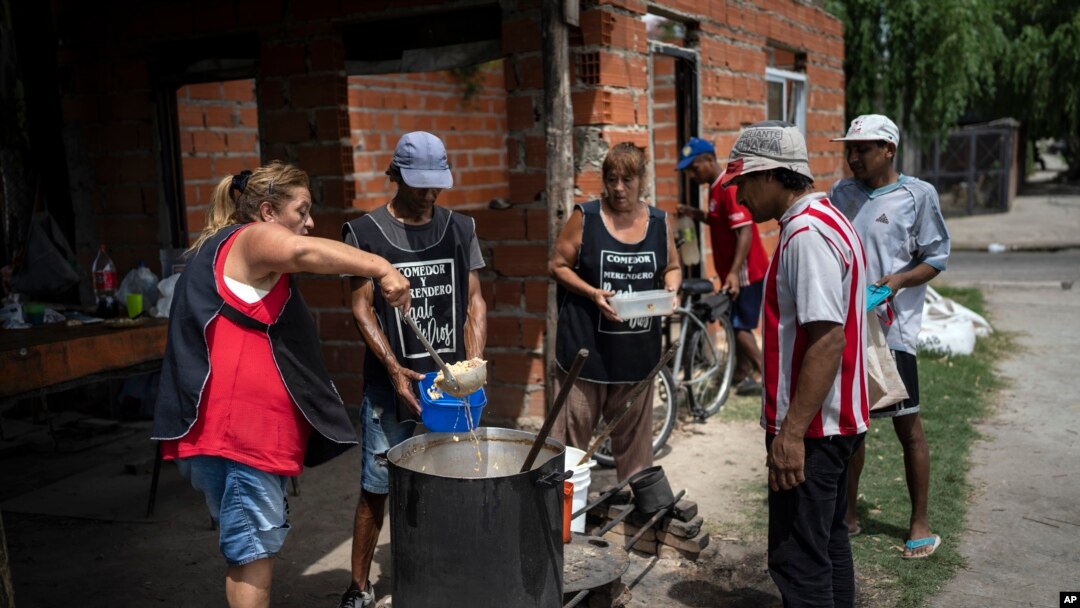 Voluntarios sirven almuerzos calientes en el comedor social "Regalo de Dios" en el barrio Libertador de Buenos Aires, Argentina, el jueves 22 de febrero de 2024.