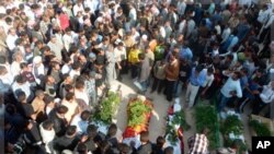 Anti-government protesters carry coffins of Sunni Muslim villagers killed in Hula, near Homs, Nov. 2, 2011.