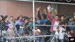 En esta foto del 27 de marzo de 2019, migrantes centroamericanos esperan comida en una estructura erigida por la Oficina de Control de Aduanas y Fronteras de EE. UU. para procesar la oleada de familias migrantes y menores no acompañados en El Paso, Texas.