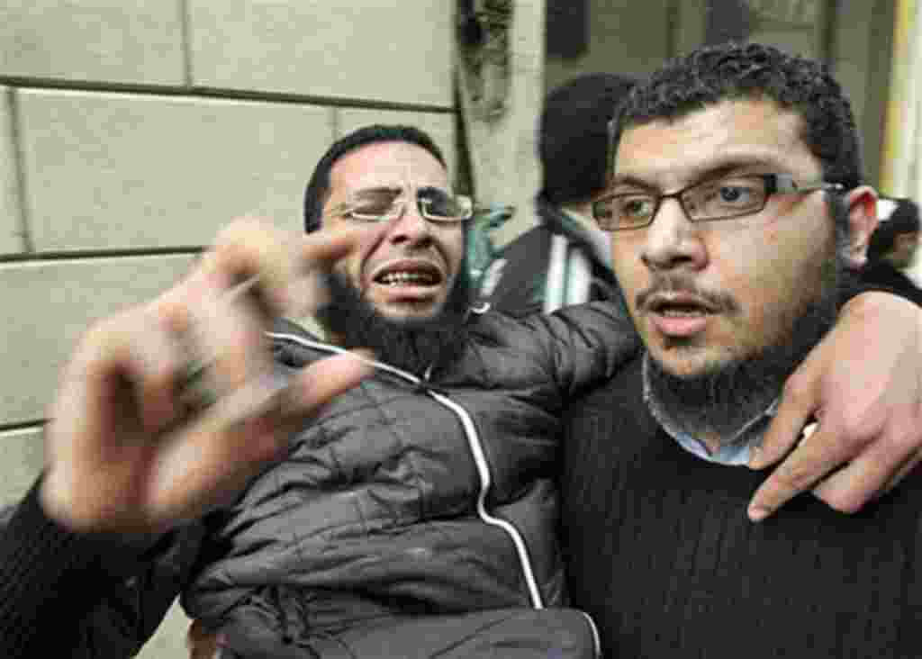 Anti-government protesters carry an injured man during clashes in Cairo's Tahrir Square, February 4, 2011