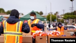 Voluntarios en Los Ángeles entregan comida a personas sin trabajo debido al impacto de la pandemia.