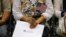 An attendee holds her new country's flag and her naturalization papers as she is sworn in during a U.S. citizenship ceremony in Los Angeles, U.S., July 18, 2017.