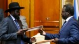 FILE - South Sudan's rebel leader Riek Machar (R) and South Sudan's President Salva Kiir (L) exchange signed peace agreement documents in Addis Ababa, Ethiopia, May 9, 2014.