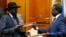 FILE - South Sudan's rebel leader Riek Machar (R) and South Sudan's President Salva Kiir (L) exchange signed peace agreement documents in Addis Ababa, Ethiopia, May 9, 2014.