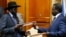 FILE- South Sudan's rebel leader Riek Machar (R) and South Sudan's President Salva Kiir (L) exchange signed peace agreement documents in Addis Ababa, Ethiopia, May 9, 2014.