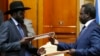 South Sudan's rebel leader Riek Machar (R) and South Sudan's President Salva Kiir (L) exchange signed peace agreement documents in Addis Ababa, Ethiopia, May 9, 2014.