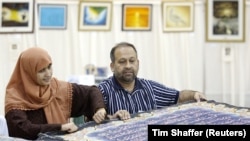 Al-Quran berwarna tulisan tangan terbesar di dunia. Seorang seniman di Pakistan telah mengambil tugas untuk menorehkan ayat-ayat Al-Qur'an di atas kanvas dengan huruf aluminium berlapis emas. (Foto: REUTERS/Tim Shaffer)