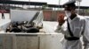 An Egyptian policeman wears a mask as he stands guard in front of a pick up truck full of pigs at the main slaughterhouse in Cairo, April 30, 2009. 