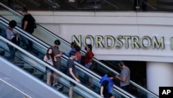 Sejumlah pengunjung tampak menggunakan masker ketika berbelanja di Nordstrom Local DTLA di Los Angeles, pada 15 Maret 2022. (Foto: AP/Damian Dovarganes)