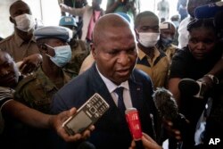 FILE - President Faustin-Archange Touadera speaks to the media after casting his vote at the Lycee Boganda polling station in the capital Bangui, Central African Republic, Sunday, Dec. 27, 2020. Touadera and his party said the vote will go ahead after government forces clashed with rebels in recent days and some opposition candidates pulled out of the race amid growing insecurity. (AP Photo)