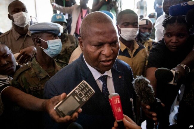 FILE - President Faustin-Archange Touadera speaks to the media after casting his vote at the Lycee Boganda polling station in the capital Bangui, Central African Republic, Sunday, Dec. 27, 2020. Touadera and his party said the vote will go ahead after government forces clashed with rebels in recent days and some opposition candidates pulled out of the race amid growing insecurity. (AP Photo)