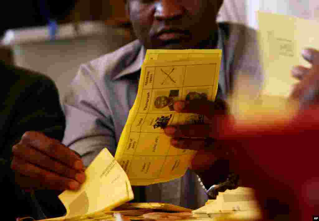 Electoral officials count ballots in Domboshawa, near the capital Harare Saturday, April 19, 2008. Officials began recounting votes for a couple dozen legislative seats, an exercise that could overturn the opposition&#39;s landmark victory. The ruling party is challenged the count in 23 constituencies, most won by the opposition.