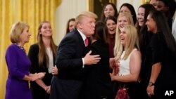 FILE - U.S. President Donald Trump hugs a member of the Oklahoma Women's Softball team as he greets members of Championship NCAA teams at the White House in Washington, Nov. 17, 2017. A new book by author Nina Burleigh will focus on Trump's relationships with women.