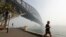 A man jogs under the Sydney Harbour Bridge as a smoke haze hangs over Sydney, Nov. 21, 2019. The annual Australian fire season, which peaks during the Southern Hemisphere summer, has started early after an unusually warm and dry winter. 