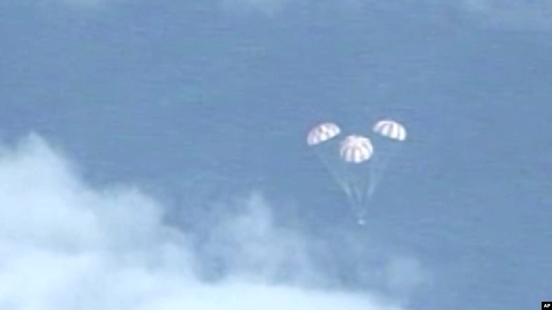 FILE - In this frame grab from NASA-TV, the Orion spacecraft descends before splashing down in the Pacific Ocean, Dec. 5, 2014.
