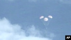 FILE - In this frame grab from NASA-TV, the Orion spacecraft descends before splashing down in the Pacific Ocean, Dec. 5, 2014.