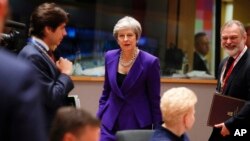 British Prime Minister Theresa May, center, arrives for a round table meeting at an EU summit in Brussels, Oct. 18, 2018.