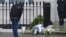 A man looks at floral tributes and messages left outside the home of former British prime minister Margaret Thatcher in London, April 9, 2013. 
