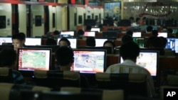 FILE - Customers surf the Internet at an Internet cafe in Beijing, China.