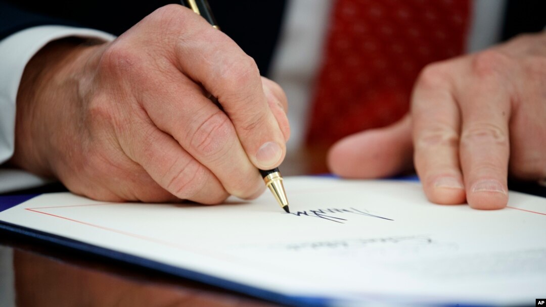 Presiden Donald Trump menandatangani executive order atau keputusan presiden, 28 Februari 2017 di Oval Office, Gedung Putih, Washington.