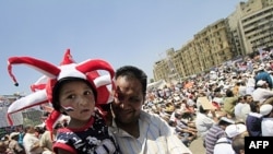 Một người mang theo đứa con trai tham gia cuộc biểu tình ở Quảng trường Tahrir trong thủ đô Cairo của Ai Cập