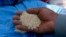 FILE - A man holds quinoa grains at a marketplace for small- and medium-sized quinoa growers in Challapata, Oruro Department, south of La Paz, Bolivia, April 19, 2014.