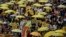 Protesters carry yellow umbrellas during a rally in a downtown street to support for a veto of the government’s electoral reform package in Hong Kong, June 14, 2015.