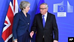 Jean-Claude Juncker, a la derecha, se prepara para dar la mano a la primera ministra británica, Theresa May, antes de su reunión en la sede de la Comisión Europea en Bruselas, Bélgica. Foto de archivo.