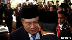 Indonesia's President Susilo Bambang Yudhoyono, left, speaks with president-elect Joko Widodo after a ceremony inaugurating a new parliament, Jakarta, Oct. 1, 2014.