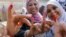 FILE - Egyptian women show their inked fingers after casting their votes at a polling station in Cairo.