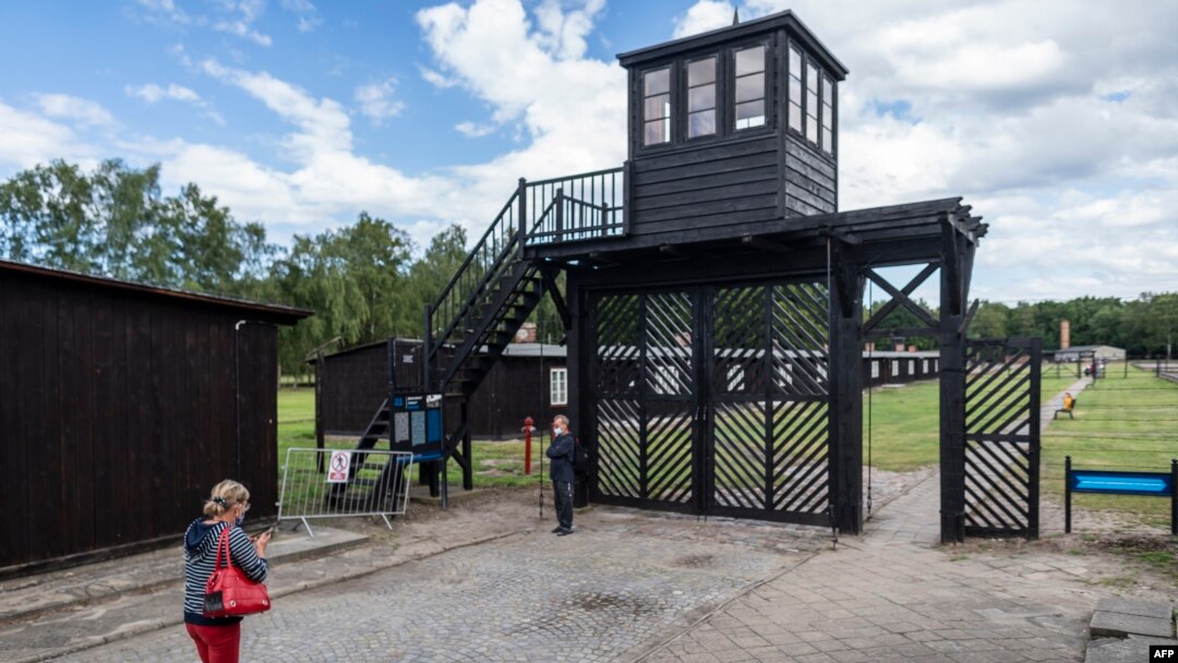 Pengunjung memandangi "Gate of Death" (Gerbang Kematian) saat mengunjungi museum Stutthof, bekas Kamp Kematian Nazi, di Sztutowo, 21 Juli 2020. (Wojtek RADWANSKI / AFP)
