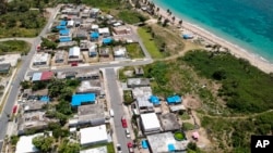 ARCHIVO - Una foto aérea de Vieques, al este de San Juan, Puerto Rico, muestra viviendas dañadas por el huracán María protegidas por cubiertas de plástico, meses después de la tormenta que devastó la isla. Junio 18, 2018.