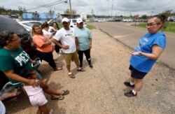 Gabriela Rosales, right, confers with friends outside the employee entrance to the Koch Foods Inc., plant in Morton, Miss., Aug. 8, 2019, that was raided Wednesday by U.S. immigration officials.