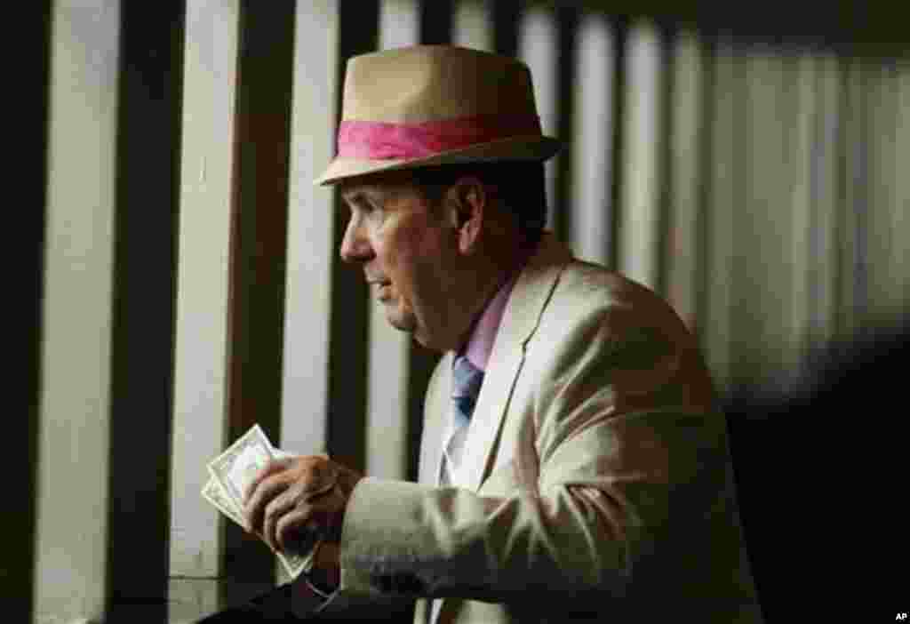 Chuck Kenney, from Goodells, Mich., places a bet before the 138th running of the Kentucky Oaks horse race at Churchill Downs Friday, May 4, 2012, in Louisville, Ky. (AP Photo/Charlie Riedel)