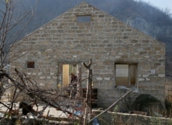 A man is seen inside a destroyed house in the village of Knaravan located in a territory which is soon to be turned over to Azerbaijan, Nov. 15, 2020.