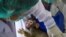 A laboratory baby monkey is being examined by employees in the breeding center at the National Primate Research Center of Thailand at Chulalongkorn University in Saraburi. Thai scientists have begun testing a COVID-19 vaccine candidate on monkeys.